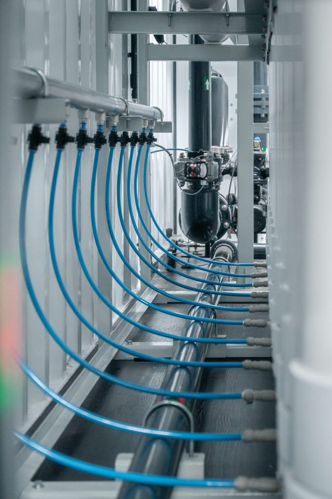 Módulos verticais de membranas de ultrafiltração com múltiplas conexões hidráulicas azuis e sistema de válvulas para tratamento de água industrial